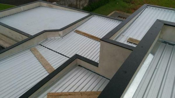 Cobertura metálica instalada em laje com calhas e acabamentos